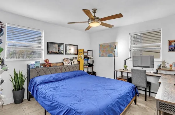 a bed room with a bed window and a flat screen tv