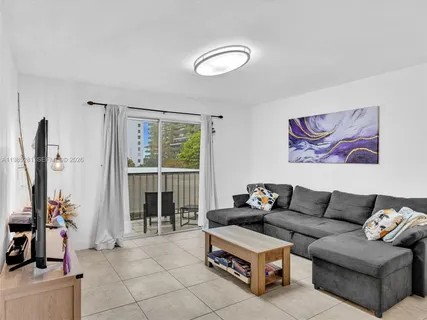 a living room with furniture and a floor to ceiling window