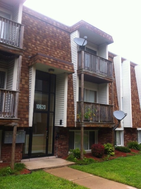 10620 Brooks Lane, Unit 2C2 Chicago Ridge, IL 60415 - Photo 1 of 12 a view of a brick building with many windows and a yard