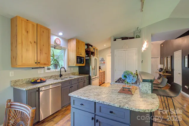 a kitchen with stainless steel appliances granite countertop a sink stove and refrigerator