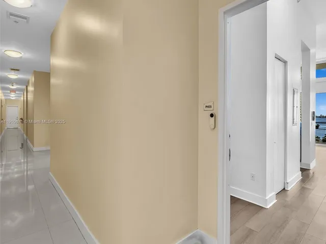 a view of a hallway with wooden floor and a living room