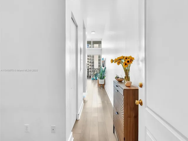 a view of a hallway with wooden floor and table