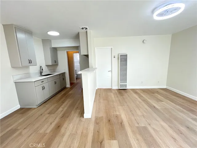 a kitchen with stainless steel appliances granite countertop a refrigerator sink and white cabinets