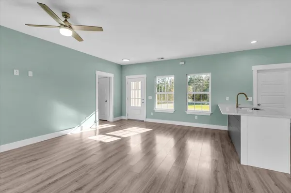 a view of an empty room with window and wooden floor