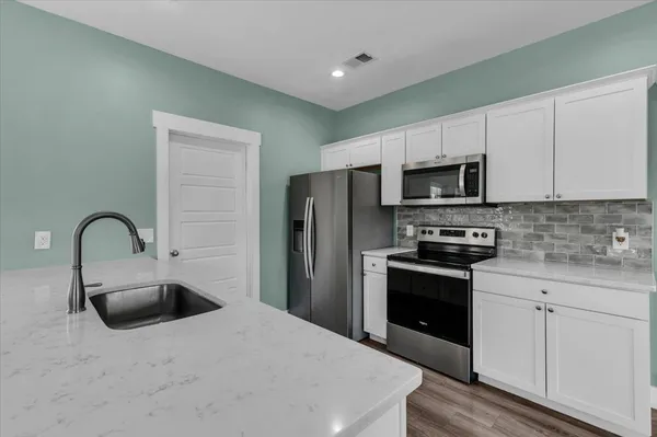 a kitchen with stainless steel appliances and refrigerator