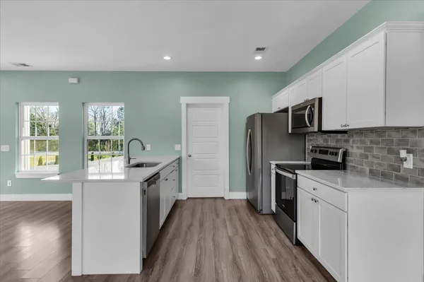 a kitchen with stainless steel appliances a stove microwave and sink