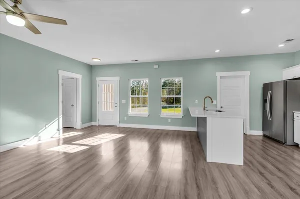 a view of kitchen with wooden floor and electronic appliances