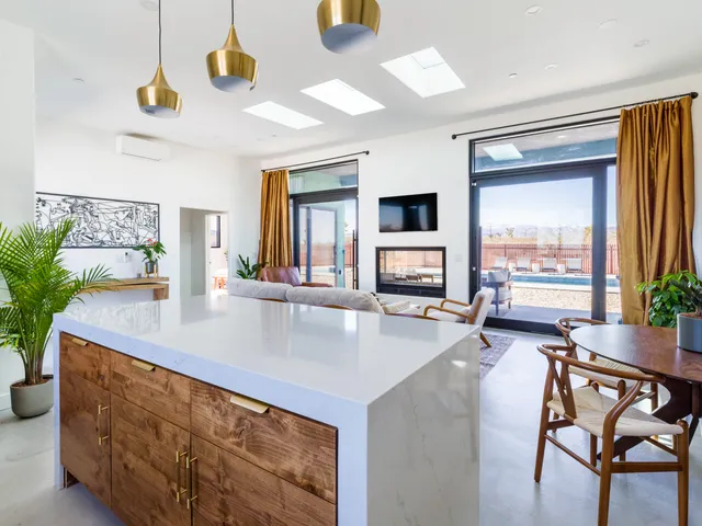a living room with furniture a rug and kitchen view