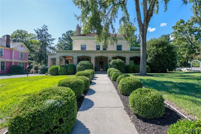 a front view of a house with a yard and potted plants