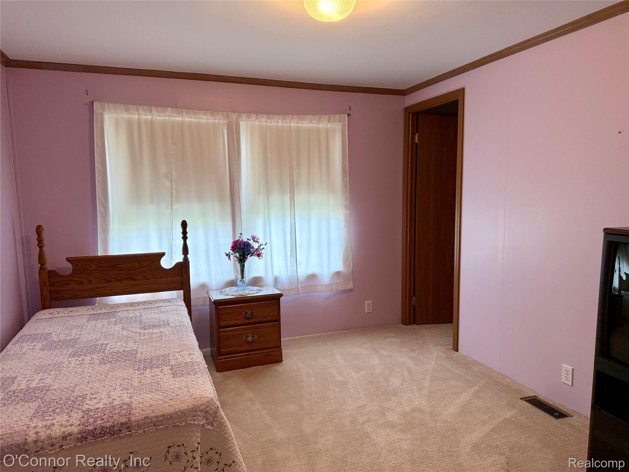 3333 Ravenswood Road, Unit 61 Marysville, MI 48040 - Photo 11 of 18 Bedroom featuring light colored carpet and ornamental molding