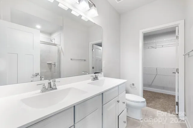 a bathroom with a sink a toilet a mirror and shower