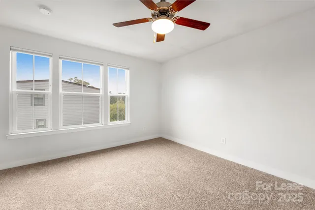 an empty room with chandelier fan