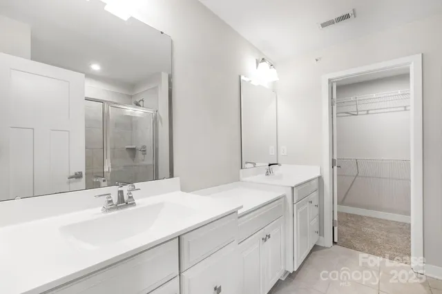 a bathroom with double sink and a mirror
