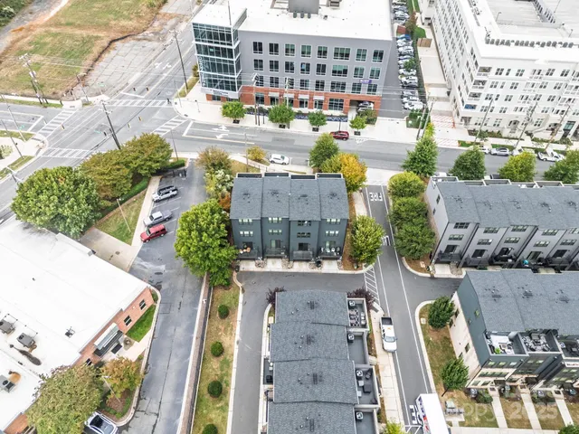 an aerial view of residential houses with outdoor space and parking