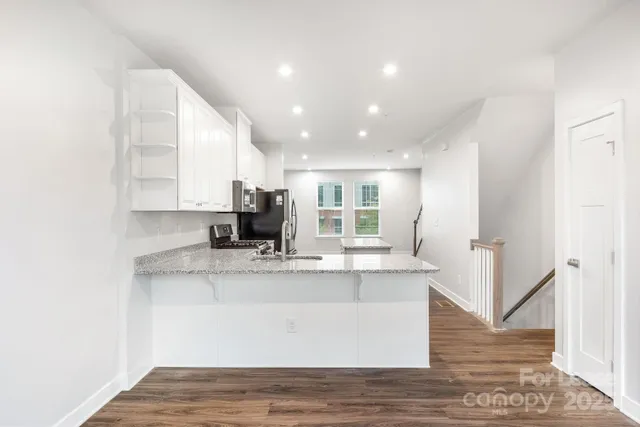 a view of kitchen with stainless steel appliances granite countertop sink
