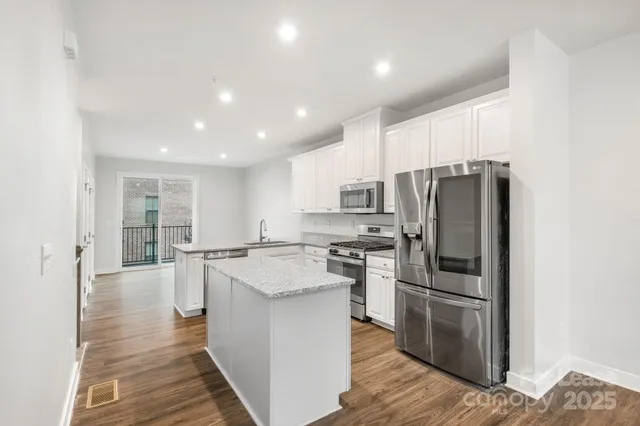 a kitchen with stainless steel appliances a refrigerator and a stove top oven
