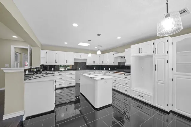 a kitchen with white cabinets and white appliances