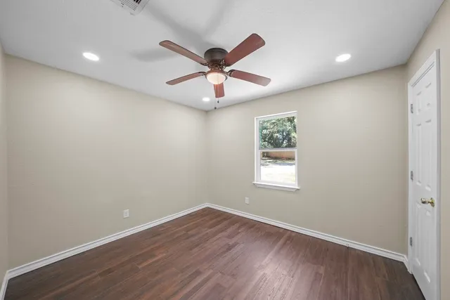 a view of a big room with wooden floor and windows in a room