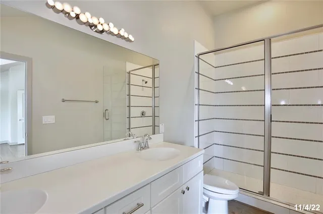 a bathroom with a granite countertop sink a toilet and shower