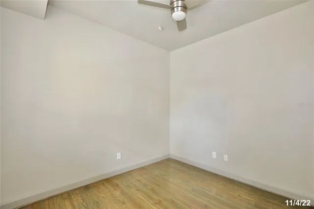 a view of an empty room with a chandelier fan