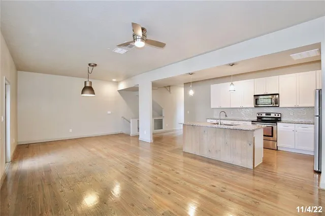 a view of kitchen with granite countertop cabinets and refrigerator