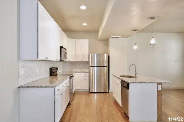 a kitchen with stainless steel appliances granite countertop a sink stove and refrigerator