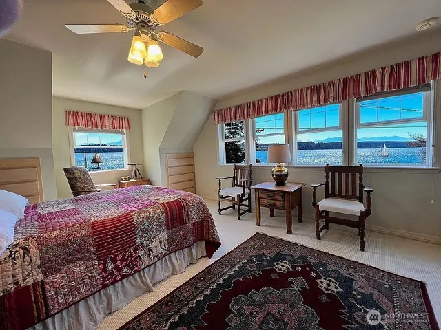 a bedroom with a bed a couch and a large window