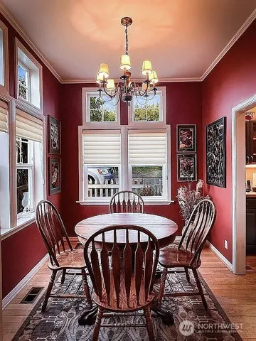 a view of a dining room with furniture a chandelier and wooden floor