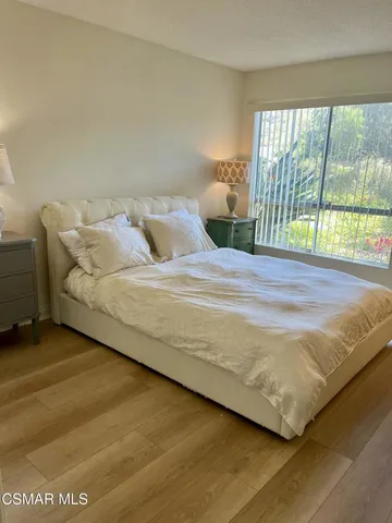 a bed sitting in a bedroom next to a window