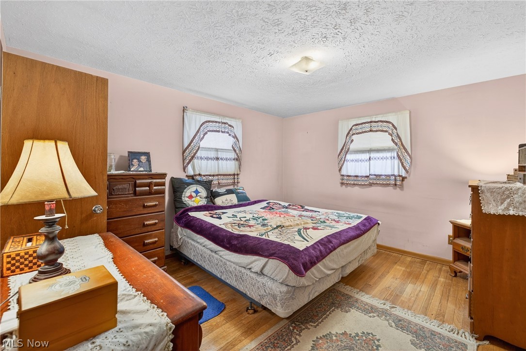 4404 Florida Street Perry, OH 44081 - Photo 11 of 24 Bedroom featuring hardwood / wood-style flooring and a textured ceiling