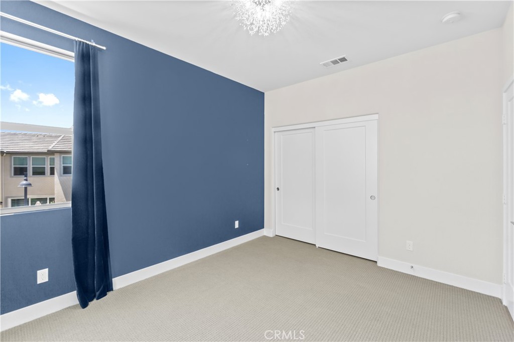 156 Chorus Irvine, CA 92618 - Photo 14 of 45 an empty room with a chandelier fan and windows