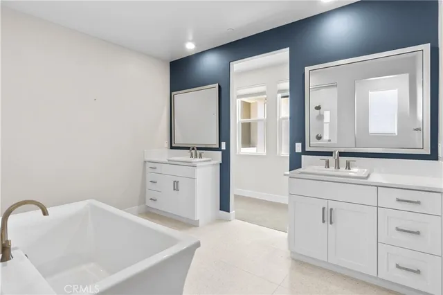 a bathroom with a bathtub sink and mirror