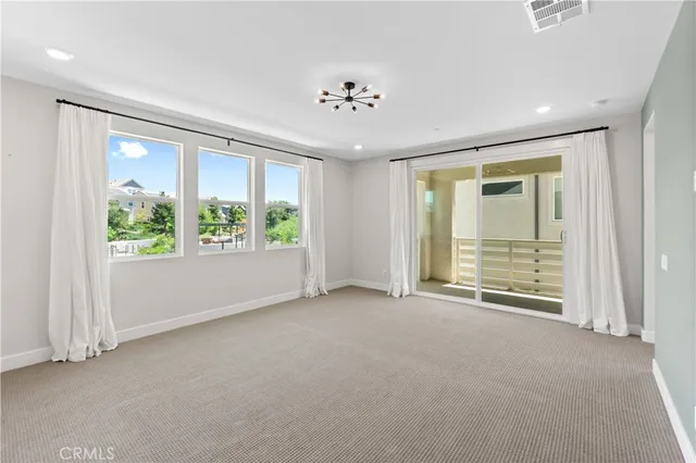 an empty room with windows and chandelier