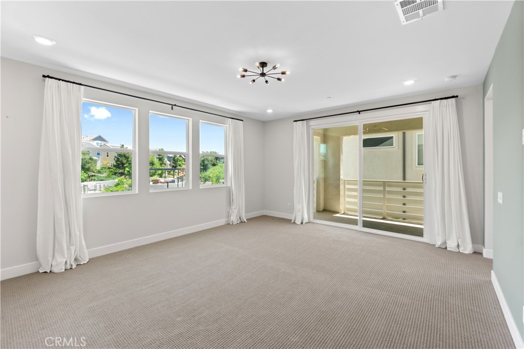 156 Chorus Irvine, CA 92618 - Photo 27 of 45 an empty room with windows and chandelier