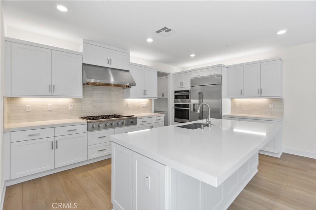 156 Chorus Irvine, CA 92618 - Photo 10 of 45 a kitchen with kitchen island a stove a sink and a refrigerator