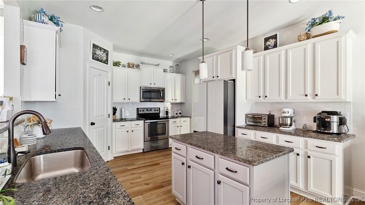 75 Bynum Court Carthage, NC 28327 - Photo 13 of 49 a kitchen with stainless steel appliances granite countertop a sink a stove a refrigerator and cabinets