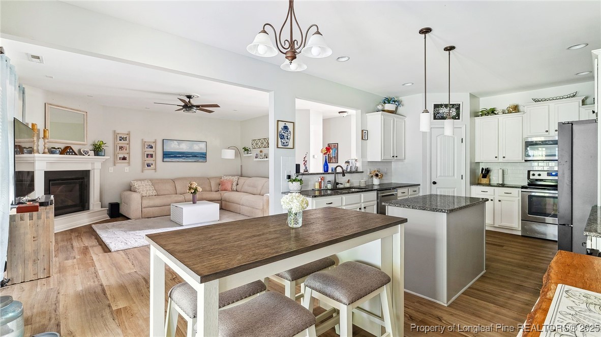 75 Bynum Court Carthage, NC 28327 - Photo 18 of 49 a kitchen with stainless steel appliances granite countertop a kitchen island a stove a table and chairs in it