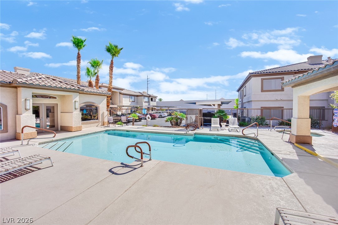 8725 West Flamingo Road, Unit 110 Las Vegas, NV 89147 - Photo 29 of 30 A sparkling pool invites relaxation, set against a backdrop of desert-friendly landscaping.