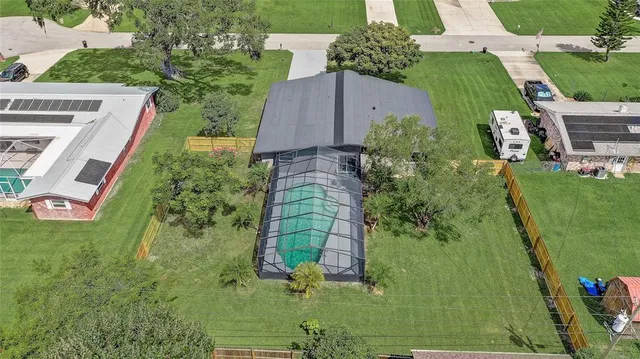 a view of a house with a big yard and large trees