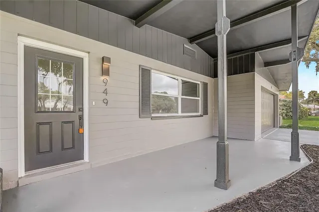 a living room with couches and kitchen view with wooden floor