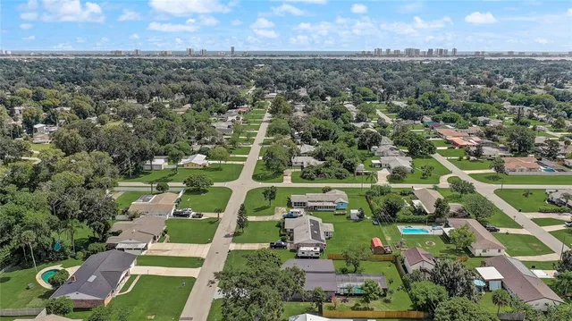 an aerial view of residential houses with outdoor space and trees
