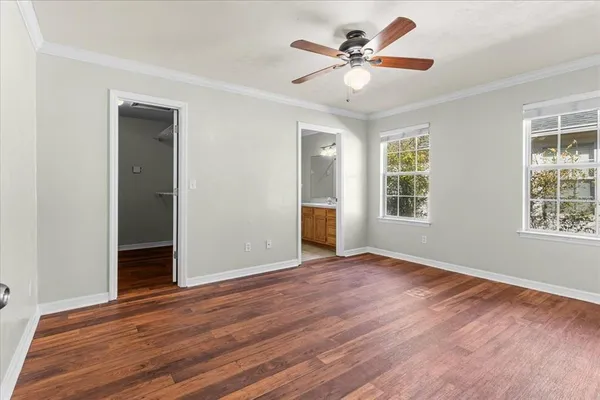 a view of an empty room with window and wooden floor