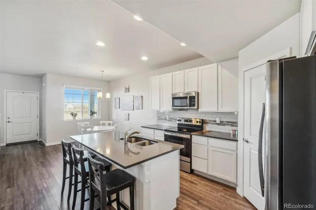 a kitchen that has a lot of cabinets a sink and appliances in it