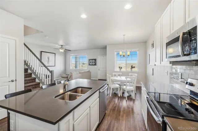 a kitchen with sink stove and refrigerator