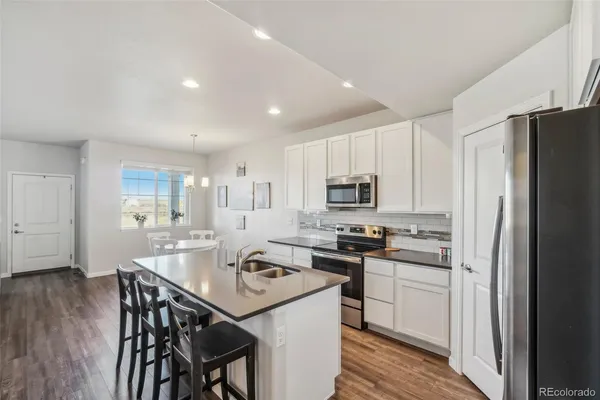 a kitchen that has a lot of cabinets a sink and appliances in it