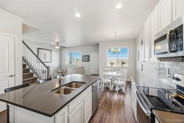 a kitchen with sink stove and refrigerator