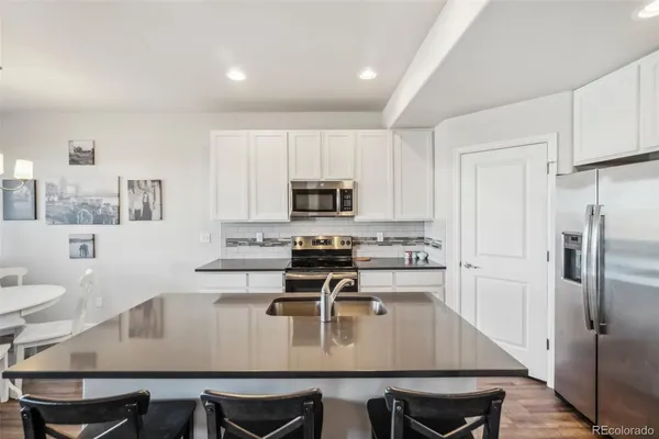 a kitchen with a dining table chairs and refrigerator
