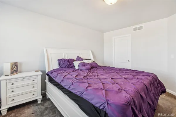 a large bed sitting in a bedroom next to a cabinet