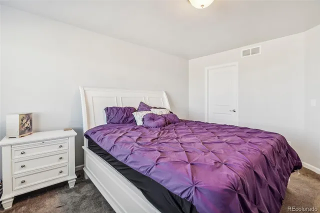 a large bed sitting in a bedroom next to a cabinet