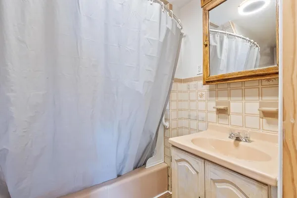 a room with a sink and white cabinets